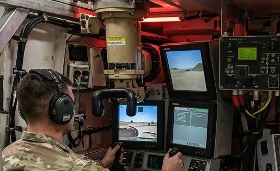 Crew cabin simulator: a servicemember wearing a headset practices combat coordination using virtual displays and controls